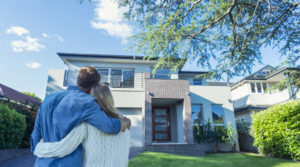 IWM-Aktuell iStock-504224016-300x167 Couple standing in front of their new home.  